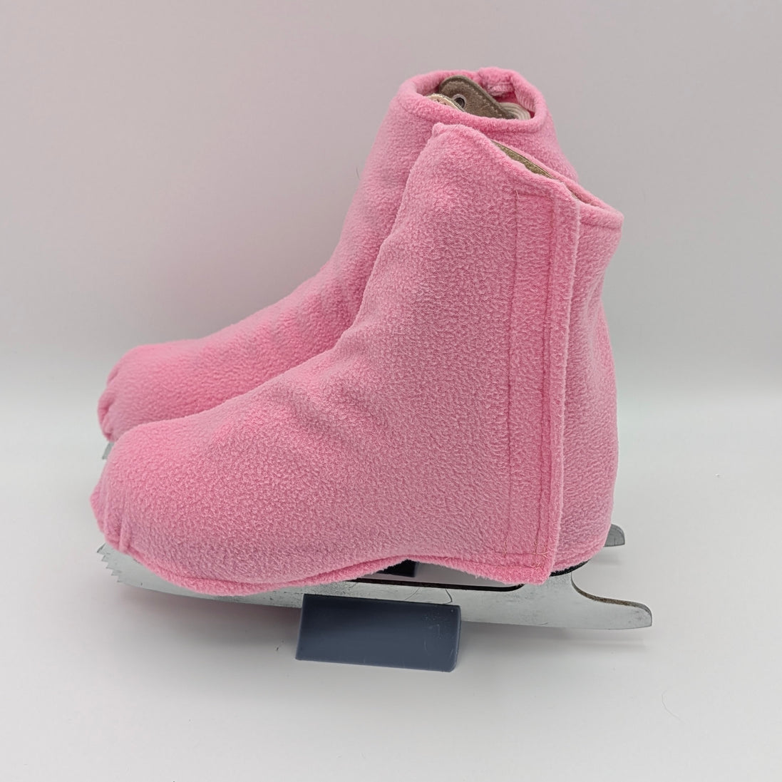Pink fleece figure skate boot covers on a white background