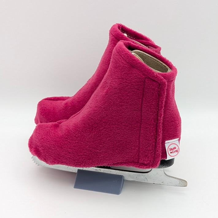 Deep pink figure skate boot covers on a white background