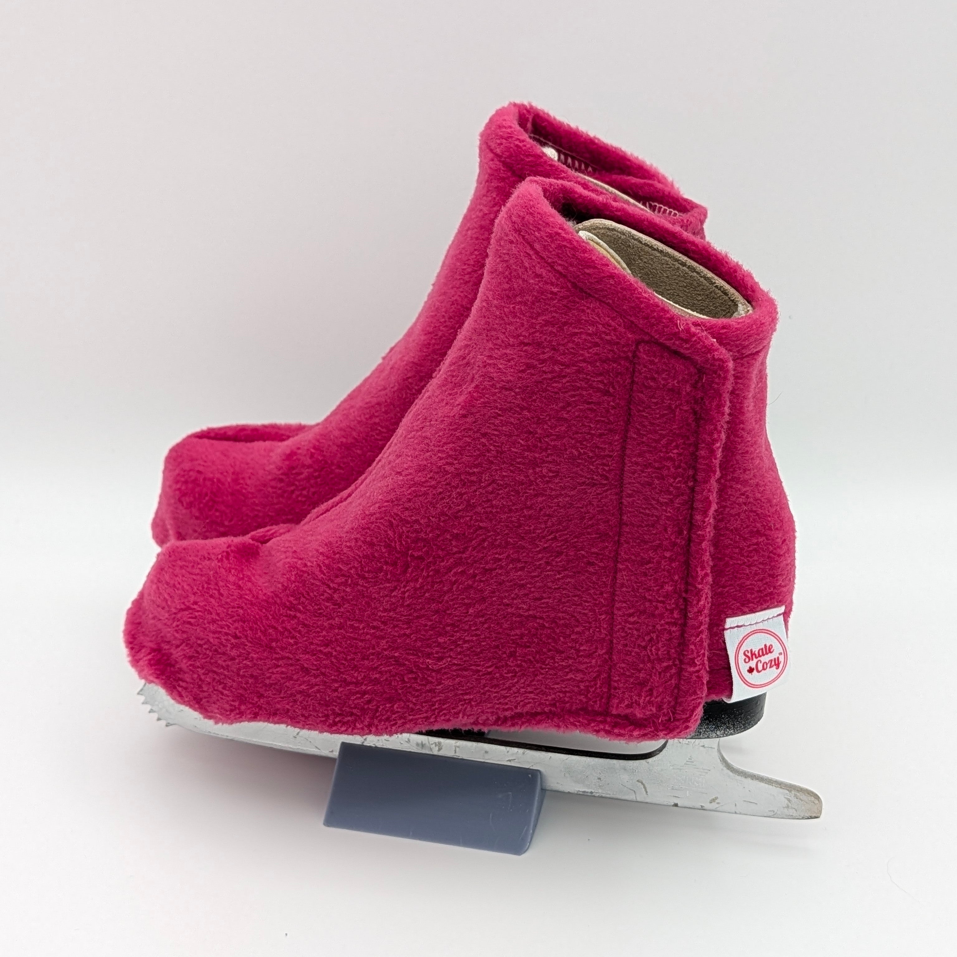 Deep pink figure skate boot covers on a white background